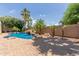 Backyard pool has a rock waterfall feature surrounded by lush, tropical landscaping and mature palm trees at 915 W Orchard Ln, Litchfield Park, AZ 85340