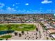 Expansive aerial view of community with a well-maintained golf course and serene pond surrounded by homes at 9654 E Foster Ave, Sun Lakes, AZ 85248