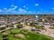 Community aerial showing a verdant golf course, lined with mature trees and surrounded by single-Gathering homes at 9654 E Foster Ave, Sun Lakes, AZ 85248