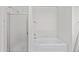A white bathtub and shower with glass doors, alongside tiled walls at 9654 E Foster Ave, Sun Lakes, AZ 85248