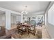 Elegant dining area with a chandelier, wood table, and seating for six, seamlessly connecting to the spacious living room at 9654 E Foster Ave, Sun Lakes, AZ 85248