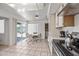 Eat-in kitchen features tile flooring, a dining area, and stainless steel appliances with access to backyard and laundry room at 9654 E Foster Ave, Sun Lakes, AZ 85248