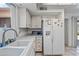 Bright kitchen featuring white cabinetry, a modern microwave, and a stainless-steel refrigerator with a water dispenser at 9654 E Foster Ave, Sun Lakes, AZ 85248