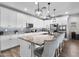 An open kitchen features white cabinetry, modern lighting, and an island with bar stool seating at 974 W Zion Way, Chandler, AZ 85248