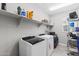 Clean laundry room with white washer and dryer, shelving, and tile flooring at 974 W Zion Way, Chandler, AZ 85248