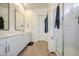 Modern bathroom with double vanity sinks, white cabinetry, and glass-enclosed shower at 9845 E Thistle Ave, Mesa, AZ 85212