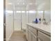 A bright bathroom with a glass shower and large vanity with white countertops at 9845 E Thistle Ave, Mesa, AZ 85212