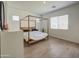 Bright bedroom features a four-poster bed, wood-style flooring, and white walls at 9845 E Thistle Ave, Mesa, AZ 85212