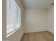 This bright bedroom features wood-style flooring and a large window at 9845 E Thistle Ave, Mesa, AZ 85212