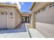 Welcoming entryway featuring a covered walkway leading to the front door between two garages at 9845 E Thistle Ave, Mesa, AZ 85212