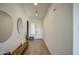 Bright, minimalist foyer with wood floors, a decorative mirror, and bench seating at 9845 E Thistle Ave, Mesa, AZ 85212