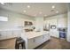 Well-lit kitchen boasts white cabinets, a large island, stainless steel appliances, and a built-in wine cooler at 9845 E Thistle Ave, Mesa, AZ 85212