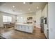 Spacious kitchen featuring a large island, stainless steel appliances, white cabinets, and adjacent dining area at 9845 E Thistle Ave, Mesa, AZ 85212