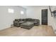 Spacious living room with a plush sofa, large windows, and a modern ceiling fan at 9845 E Thistle Ave, Mesa, AZ 85212