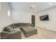 Spacious living room with a plush sofa, large windows, and a modern ceiling fan at 9845 E Thistle Ave, Mesa, AZ 85212