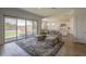 Bright living space with hardwood floors, an area rug, and sliding door access to the outdoor space at 9845 E Thistle Ave, Mesa, AZ 85212