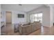 Spacious living room with a comfortable sofa, hardwood floors, and a sliding glass door at 9845 E Thistle Ave, Mesa, AZ 85212