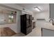 View of the kitchen with modern appliances that opens to another room filled with light at 9929 W Thunderbird Blvd, Sun City, AZ 85351