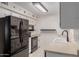 Functional kitchen features modern black appliances, white cabinetry, and neutral countertops at 9929 W Thunderbird Blvd, Sun City, AZ 85351
