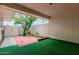 Cozy patio area with artificial grass, brick pavers, and a mature tree providing shade at 9929 W Thunderbird Blvd, Sun City, AZ 85351