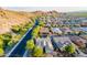 Scenic aerial view of a neighborhood near a mountain, lush trees, and a roadway at 10207 W Hedge Hog Pl, Peoria, AZ 85383