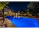 Backyard oasis: illuminated pool, spa, lush greenery, and outdoor seating for relaxation and entertainment at 10207 W Hedge Hog Pl, Peoria, AZ 85383