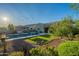 Open backyard featuring a pool, verdant artificial grass, mature trees, and an inviting lounge area at 10207 W Hedge Hog Pl, Peoria, AZ 85383