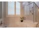 This full bath has a tub with glass shower doors and a large, bright window at 10207 W Hedge Hog Pl, Peoria, AZ 85383