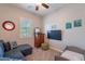 Bright bedroom with a ceiling fan and a window with shutters at 10207 W Hedge Hog Pl, Peoria, AZ 85383