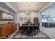 A dining room with a wooden table, blue rug, a mirror, and a view of the kitchen at 10207 W Hedge Hog Pl, Peoria, AZ 85383