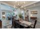 Open-concept dining room featuring a wooden table with runner, modern lighting, and seamless access to the living area at 10207 W Hedge Hog Pl, Peoria, AZ 85383