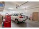 Well-lit garage featuring a SUV, storage solutions, and a red toolbox for organization at 10207 W Hedge Hog Pl, Peoria, AZ 85383