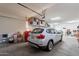 Spacious garage featuring a modern SUV, ample storage shelves and overhead racks for organization at 10207 W Hedge Hog Pl, Peoria, AZ 85383