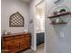 Hallway to powder room features tile floors, gray walls, shelving, and an antique wood chest at 10207 W Hedge Hog Pl, Peoria, AZ 85383