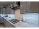 Elegant kitchen with gas cooktop, white backsplash, and gray cabinets at 10207 W Hedge Hog Pl, Peoria, AZ 85383