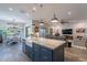 Kitchen island with navy cabinets, marble countertop, and pendant lighting. Living room in the background at 10207 W Hedge Hog Pl, Peoria, AZ 85383
