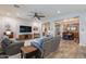 Open-concept living room with stone accent wall, modern furnishings, and seamless flow to the dining area at 10207 W Hedge Hog Pl, Peoria, AZ 85383