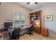 This home office has built-in shelving, wood floors, and a bright window at 10207 W Hedge Hog Pl, Peoria, AZ 85383