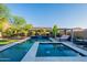Sparkling pool and spa featuring travertine decking and lush landscaping for a resort-like experience at 10207 W Hedge Hog Pl, Peoria, AZ 85383