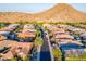 Bird's eye view down a residential street lined with houses in a suburban neighborhood near a desert mountain at 10207 W Hedge Hog Pl, Peoria, AZ 85383