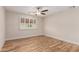 A cozy bedroom boasts wood floors, a fan, and shuttered windows at 10318 E Michigan Ave, Sun Lakes, AZ 85248