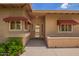 Home front entrance with an attractive door, awnings, brick siding, and well-maintained landscaping at 10318 E Michigan Ave, Sun Lakes, AZ 85248