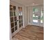Bright entryway features attractive wood-look floors and a three-panel modern glass front door at 10318 E Michigan Ave, Sun Lakes, AZ 85248