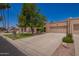Desert-style house featuring a xeriscaped yard, wide driveway, and a large shade tree in the front at 10318 E Michigan Ave, Sun Lakes, AZ 85248