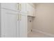 Bright laundry room with ample storage cabinets and modern tile flooring at 10318 E Michigan Ave, Sun Lakes, AZ 85248