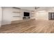 Bright living room featuring hardwood floors, built-in shelving, a cozy fireplace, and a ceiling fan at 10318 E Michigan Ave, Sun Lakes, AZ 85248