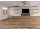 A spacious living room features hardwood floors, built-in shelving, a fireplace, and a ceiling fan at 10318 E Michigan Ave, Sun Lakes, AZ 85248