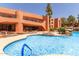 Resort-style pool is featured with blue railings, stone landscaping, and a building backdrop at 12222 N Paradise Village S Pkwy # 237, Phoenix, AZ 85032