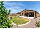 Expansive backyard boasts a covered patio, manicured lawn, and tasteful landscaping for serene outdoor living at 128 S 200Th Ave, Buckeye, AZ 85326