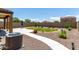Well-maintained backyard featuring a covered patio, green lawn, and thoughtfully designed landscaping at 128 S 200Th Ave, Buckeye, AZ 85326